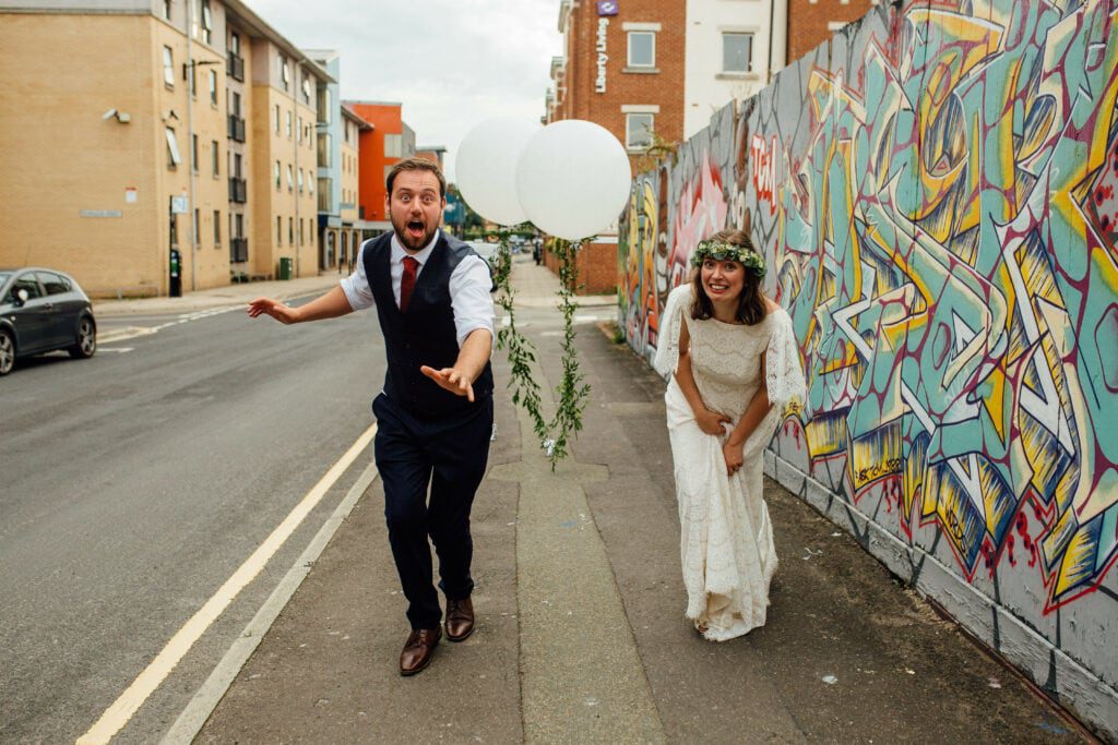 bride and groom having fun with giant balloons