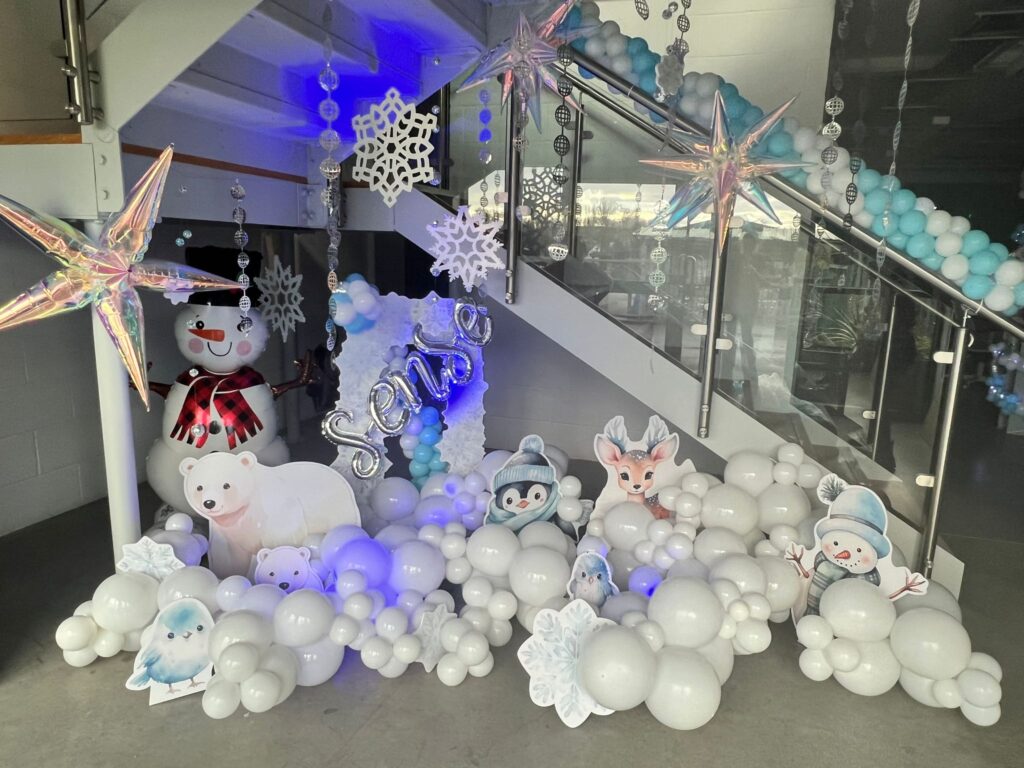 Winter-themed balloon installation under stairs with polar bears, snowmen, and snowflakes in a South Yorkshire office.