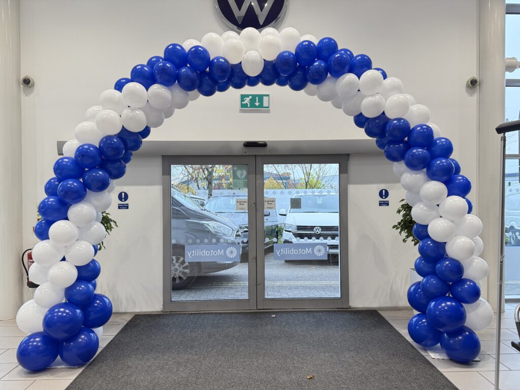 Balloon décor FAQ: a swirl garland arch installed for a corporate event