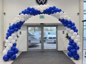 Balloon décor FAQ: a swirl garland arch installed for a corporate event