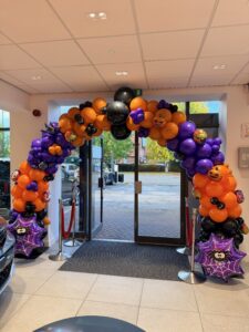 Halloween balloon arch installed for a car dealership showroom