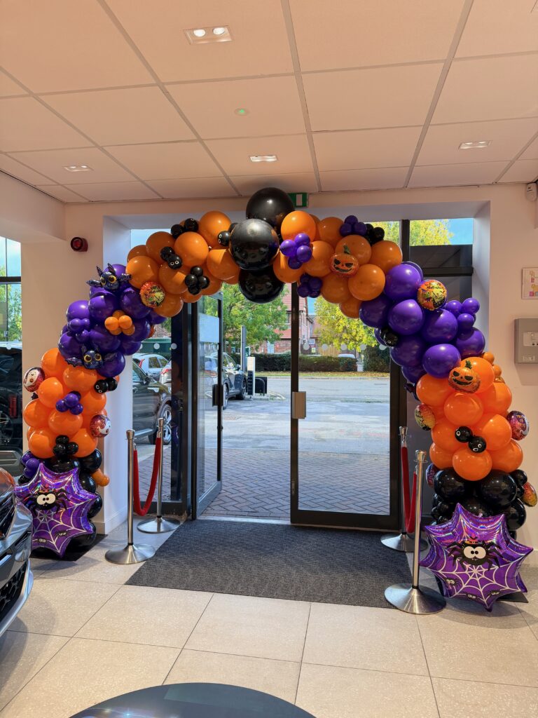 Halloween balloon arch installed for a car dealership showroom